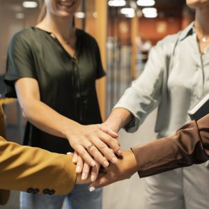 close-up-colleagues-putting-hands-together (1)