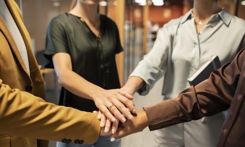 close-up-colleagues-putting-hands-together (1)