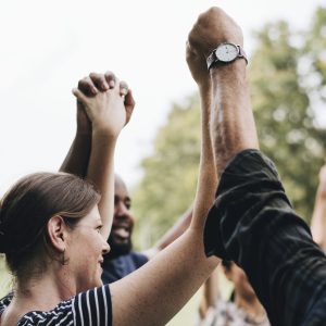 Happy diverse people holding hands in the park